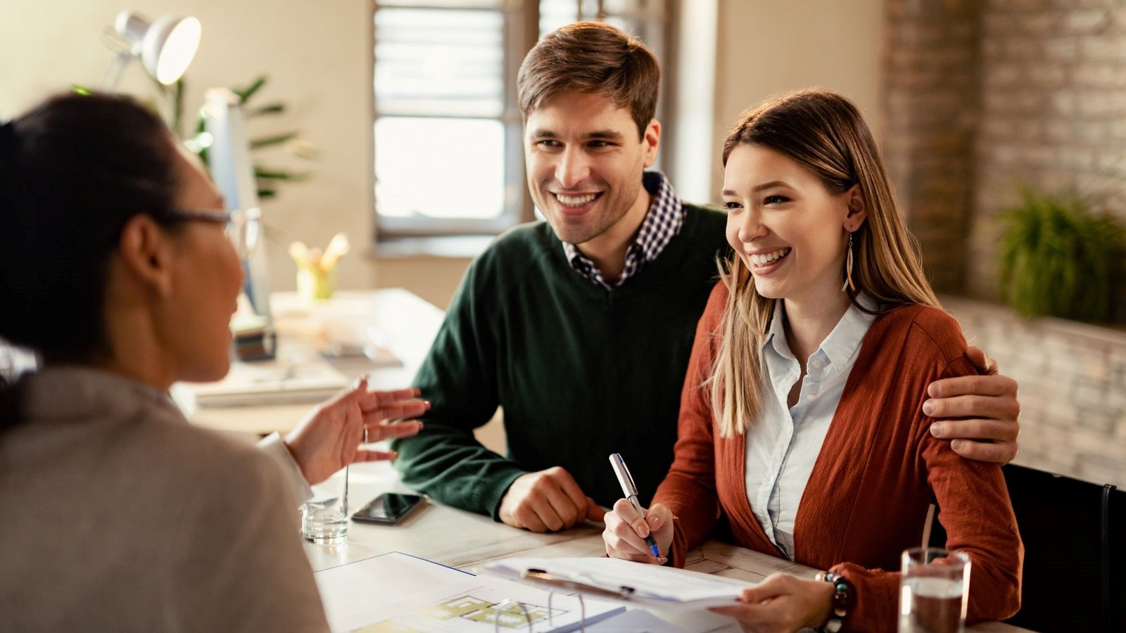 A real estate property agent having a home buying contract with couple